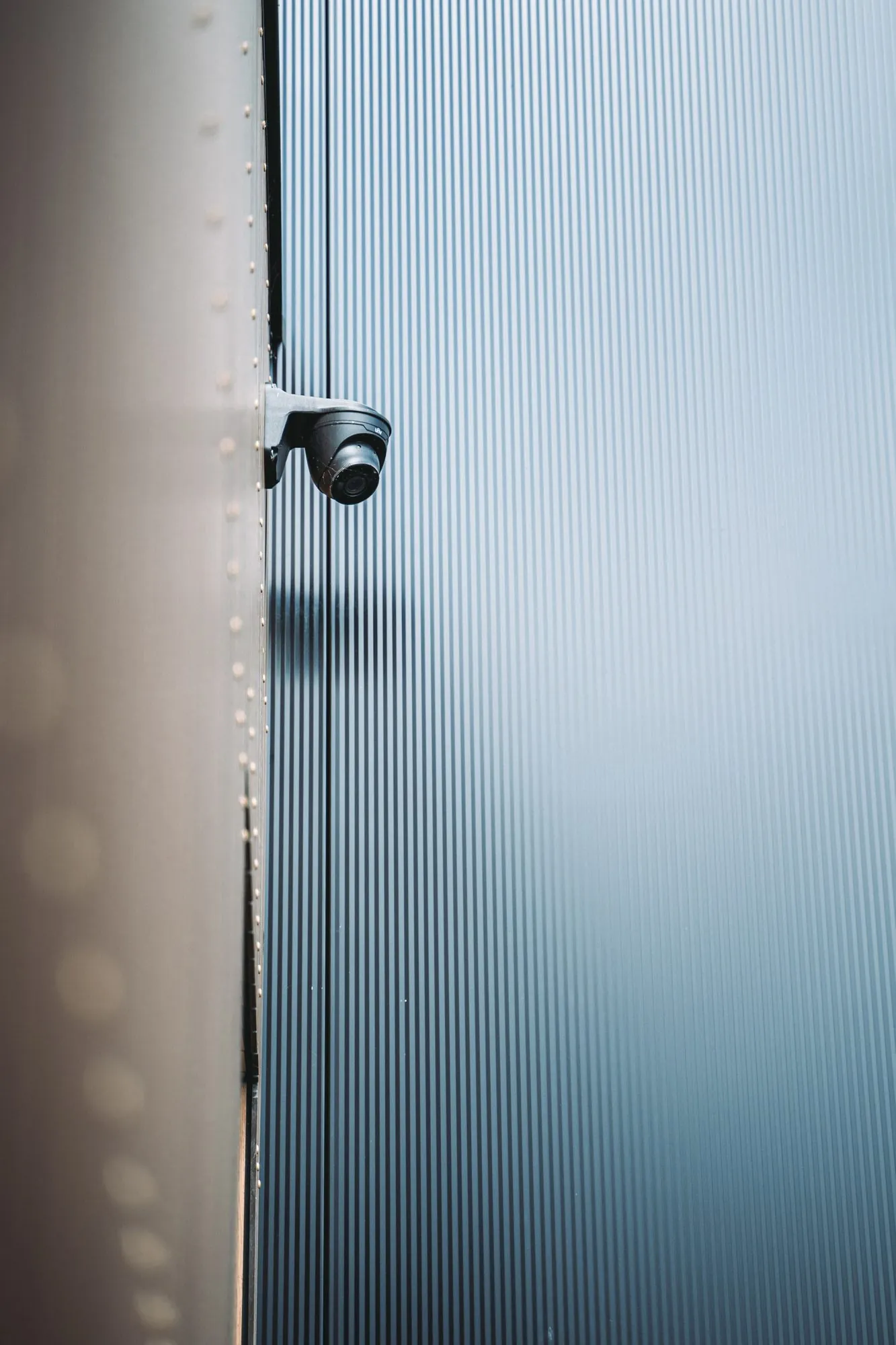 Beveiligingscamera gemonteerd op de golfwand van een industrieel gebouw