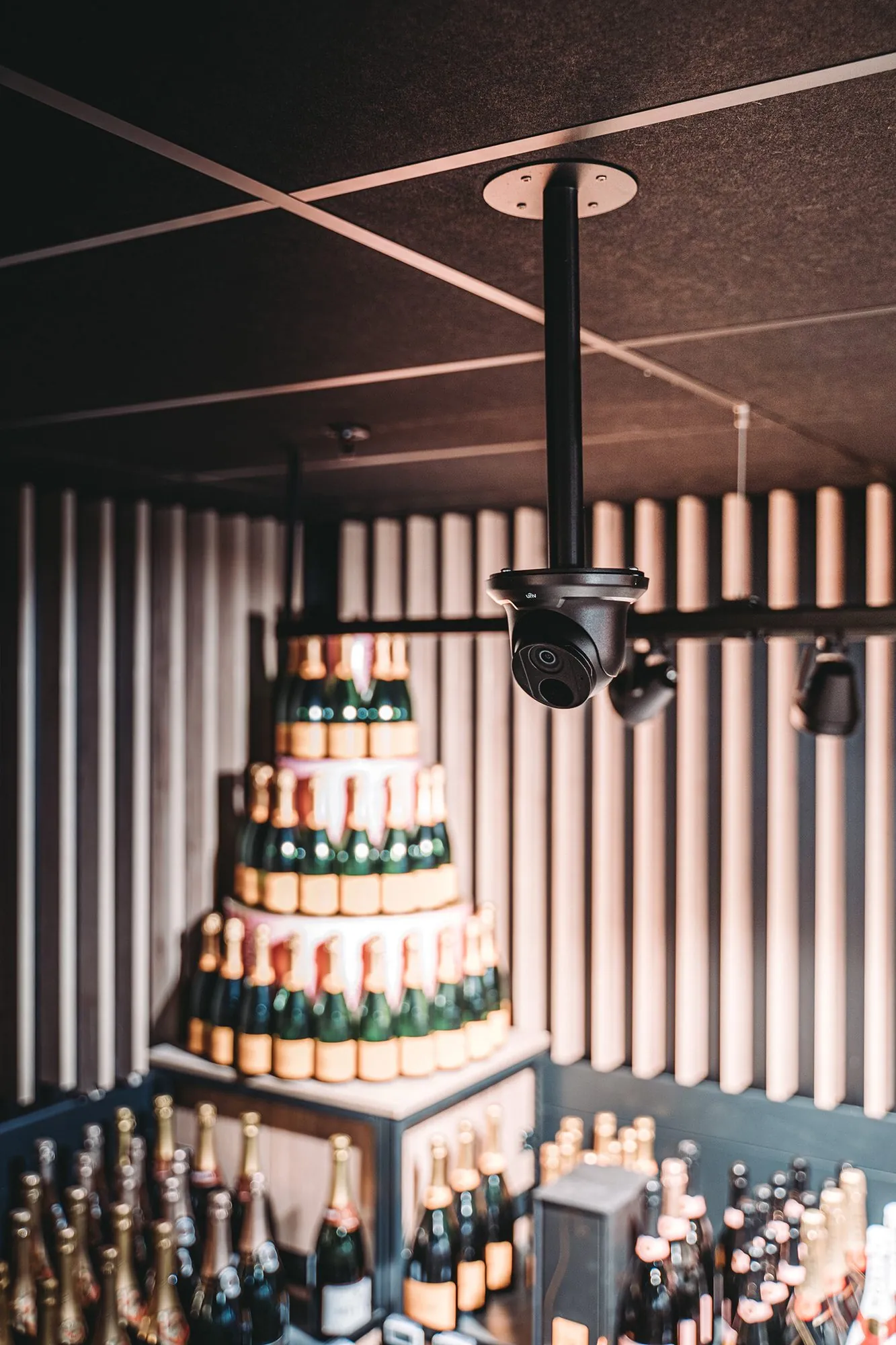 Zwart camerasysteem aan plafond gericht op feestlocatie met drank en versiering